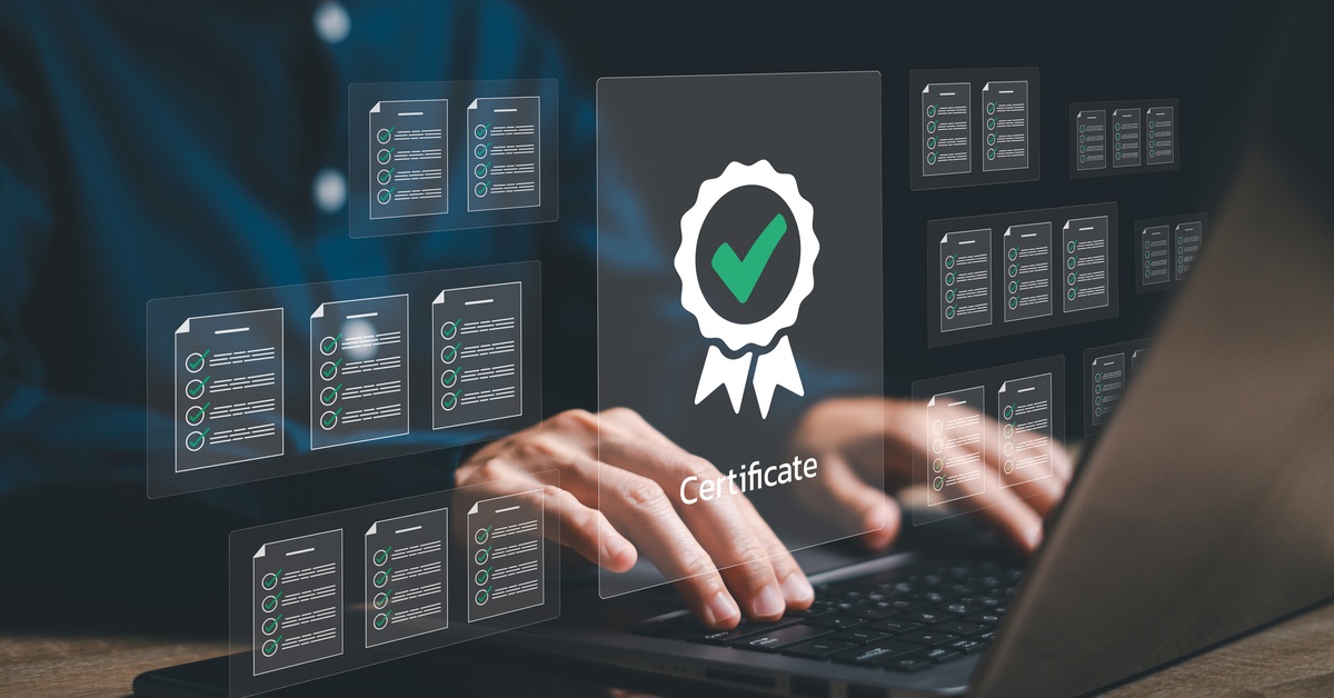 A person typing on a laptop with a transparent icon of a white ribbon, green check mark, and the word "certificate" above it.