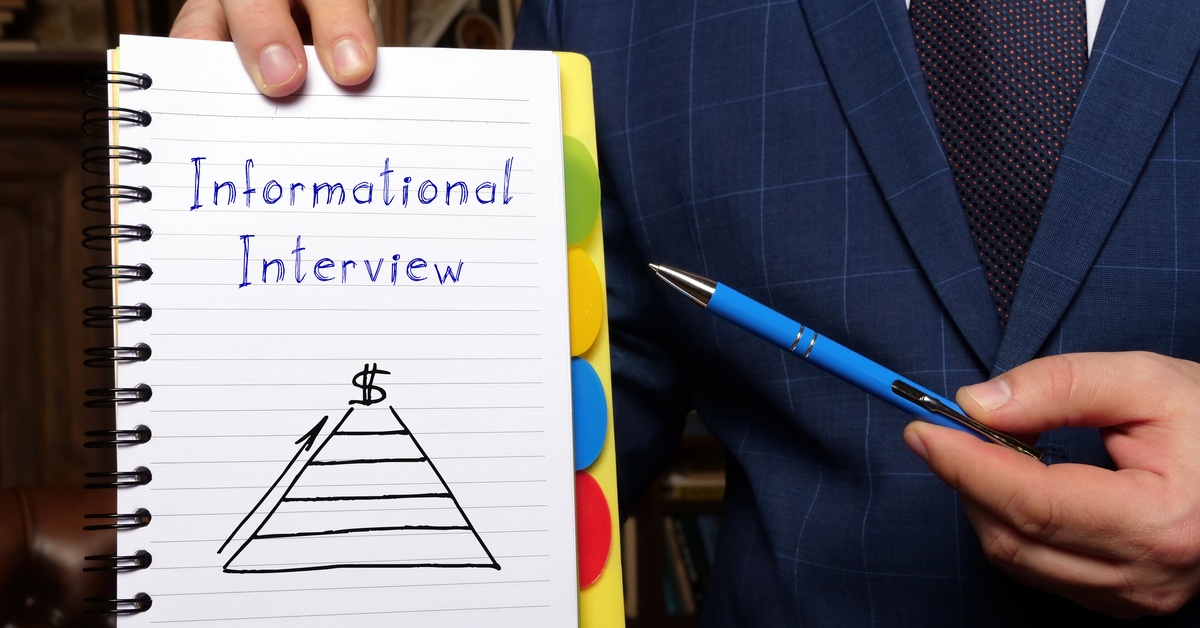A person wearing a business suit holding a notepad with the words "Informational Interview" and a pyramid on it.