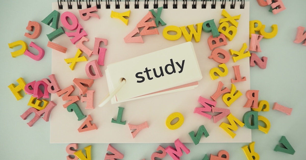 A notebook with a tag that has the word "study" on it surrounded by colorful magnets in the shape of English letters.