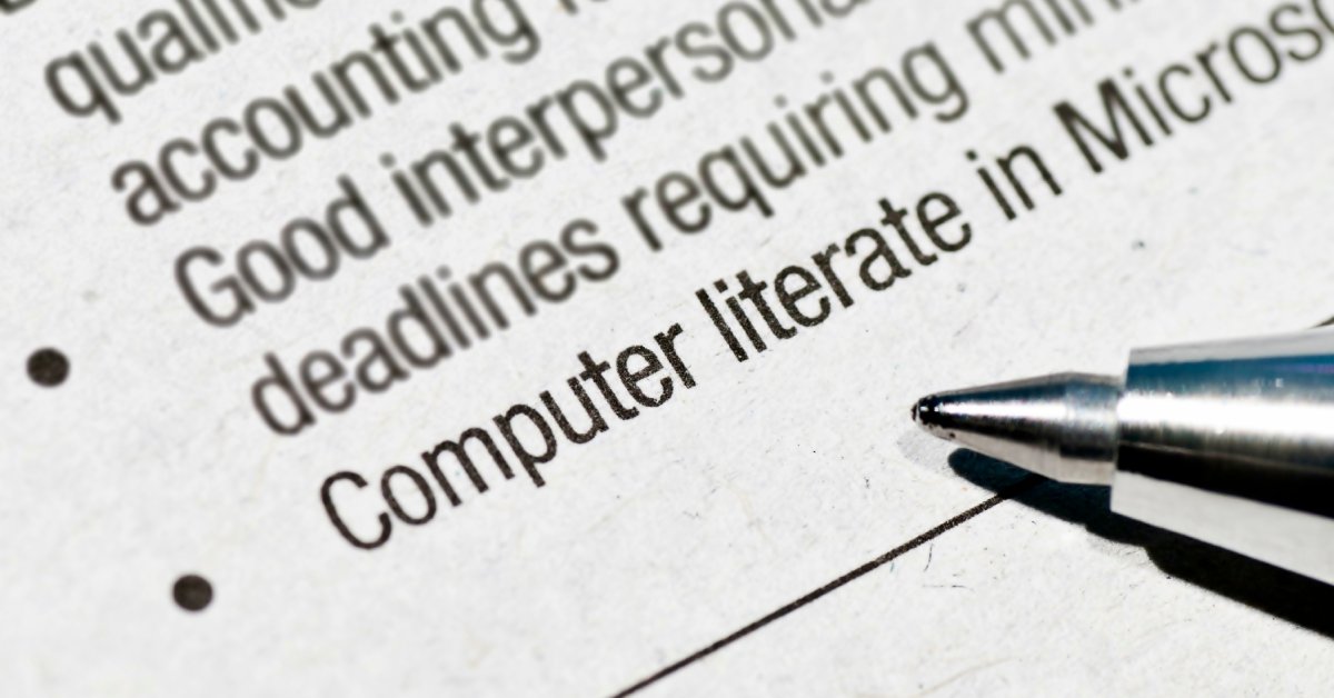 A close-up of a printed job description with the tip of a silver pen laying near a bulleted list of skills.
