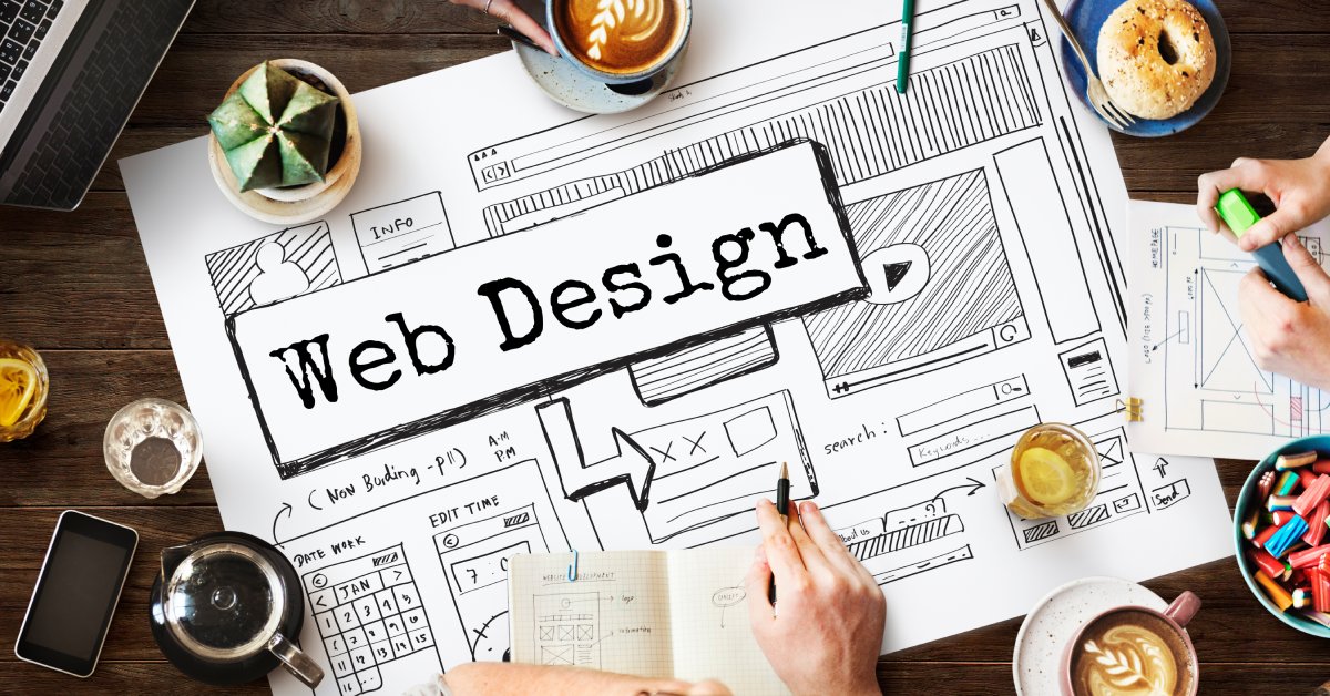 A large white sheet of paper with the words "Web Design" on it, along with sketches of a calendar, video player, and more.