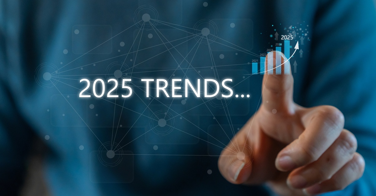 A person using their finger to point to a graph where 2025 has a larger bar than past years, next to the words "2025 Trends."
