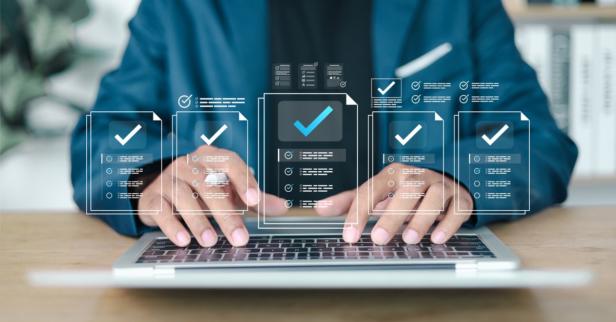 Hands on laptop keyboard with virtual checklist panels and check marks representing digital workflow and task tracking.